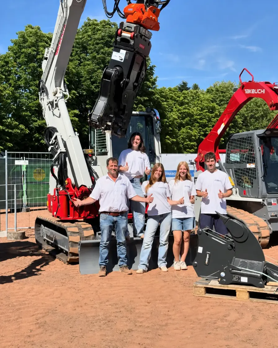 Das MHW-Team steht gemeinsam vor zwei Takeuchi-Baggern