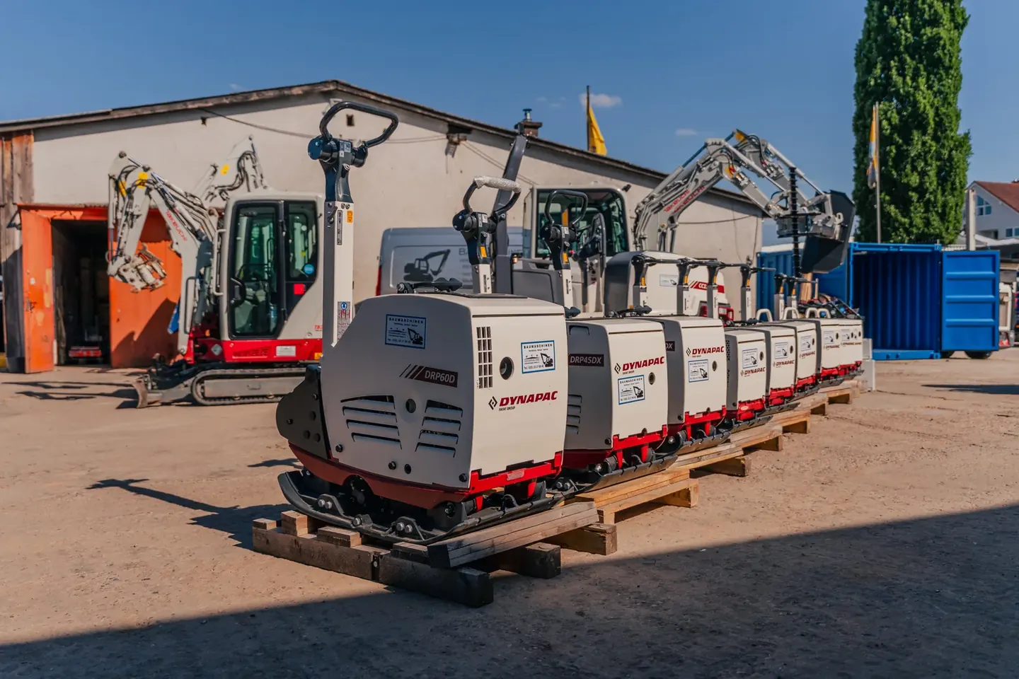 Dynapac-Rüttelplatten stehen vor Takeuchi-Baggern auf dem MHW-Hof